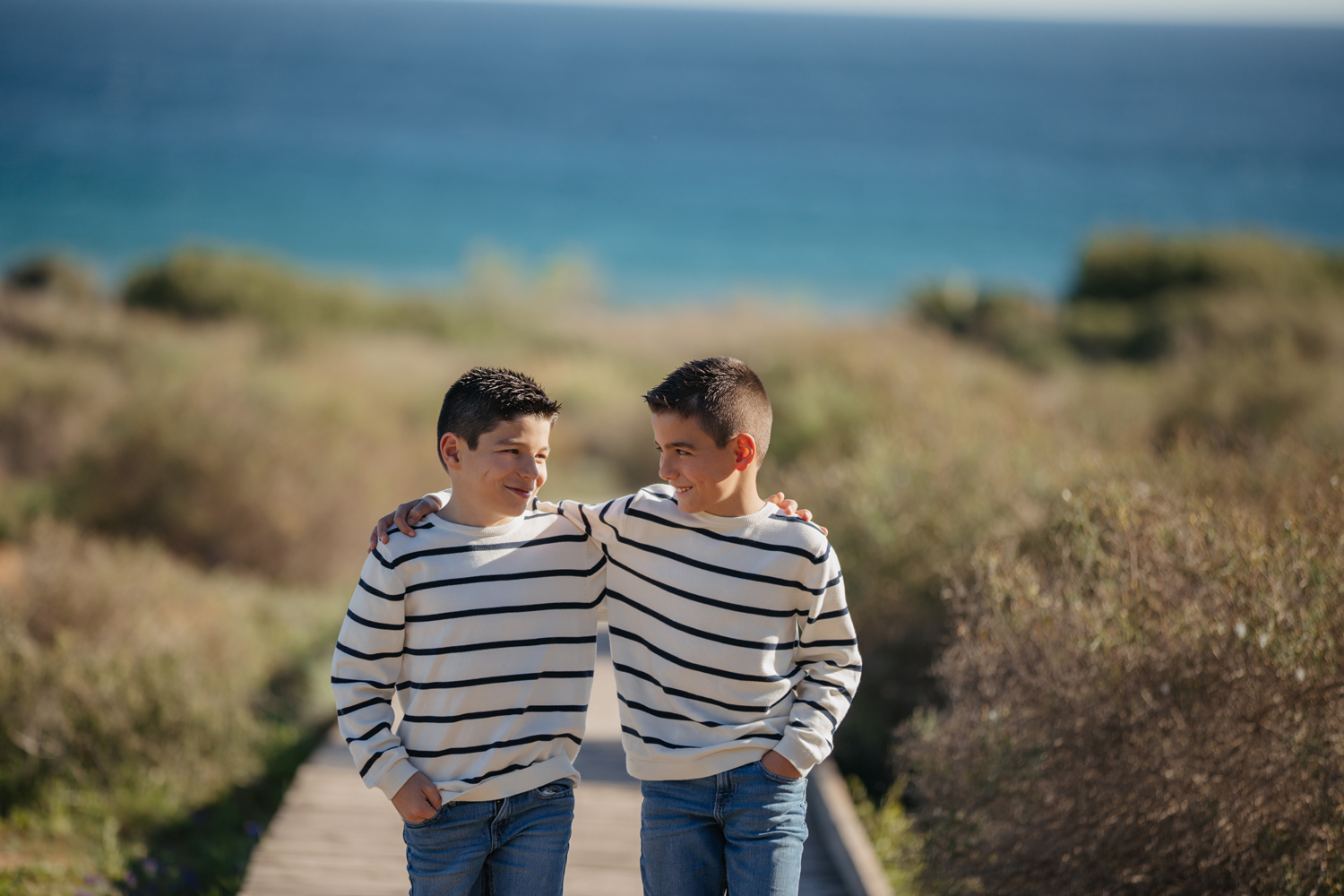 Hermanos corriendo en pasarela de playa
